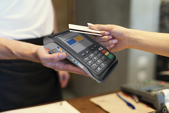 Hand of woman using payment terminal in an electrical shop