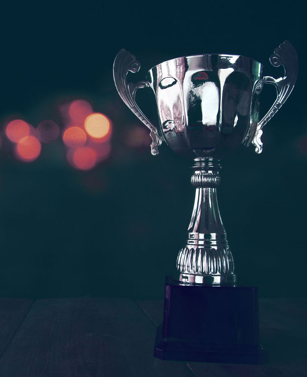 image of trophy over wooden table and dark background