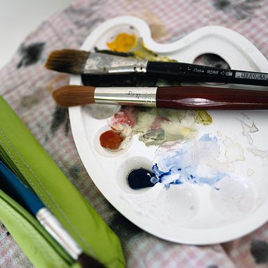 Malpaletti mit Farben und Pinseln