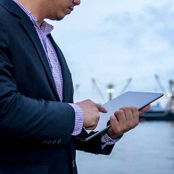 Mann mit Tablet am Hafen