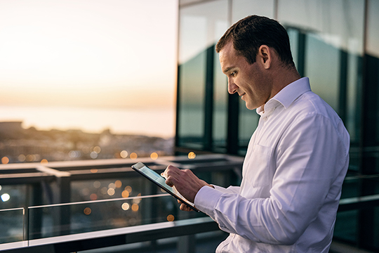 Man holding tablet on his balcony