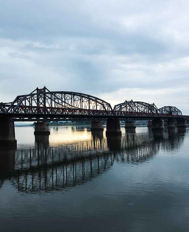 Brücke über einen Fluss in untergehender Sonne