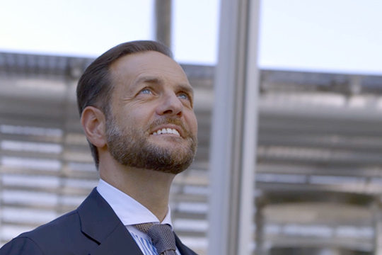 Man in front of a building is smiling
