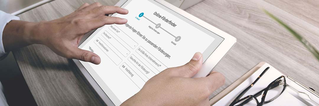 Jemand hält ein Tablet in der Hand auf dem der Bank Austria Förderfinder zu sehen ist