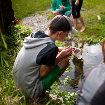 Ein Kind in den Österreichischen Nationalparks beim Erforschen der Wasserwelt