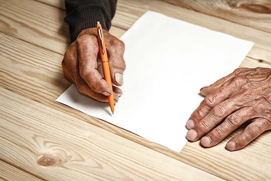 The old man wrote a testament, sitting at a wooden table