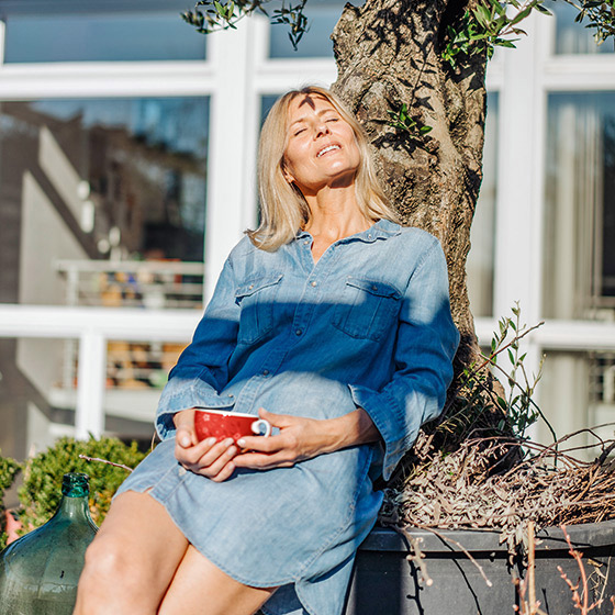 Eine Frau sonnt sich im Garten