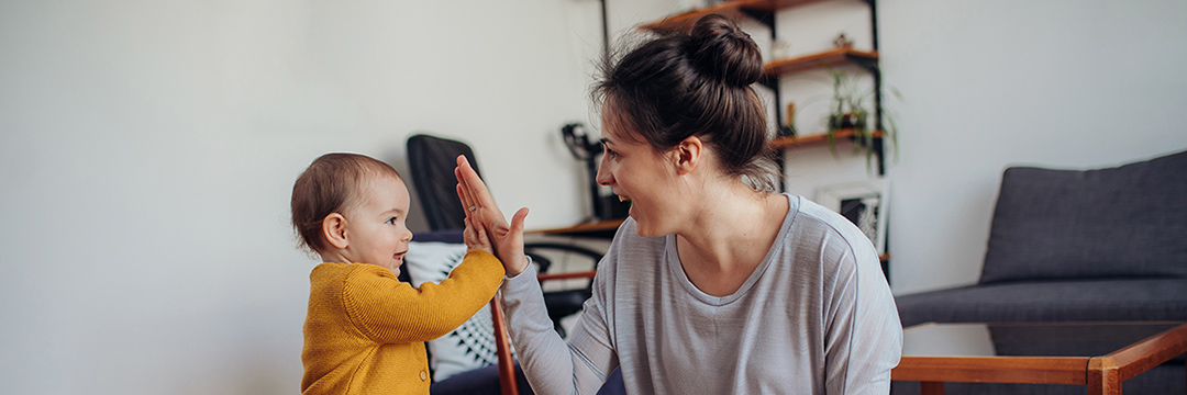 Eine Mutter mit ihrem kleinen Kind, sie klatschen sich in die Hände