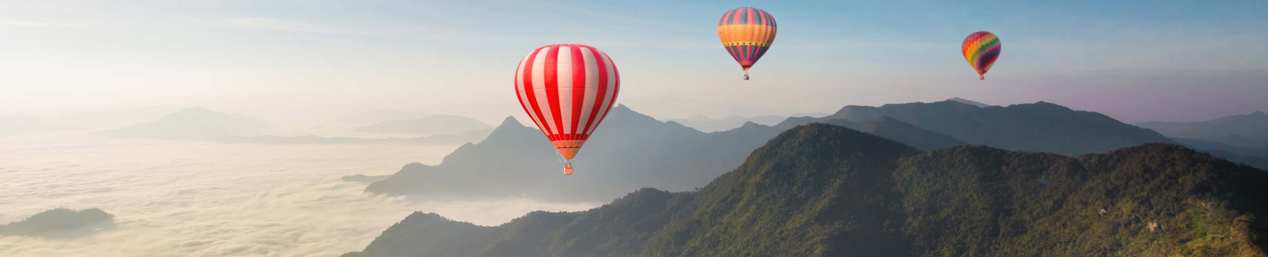 Heißluftballone über den Bergen