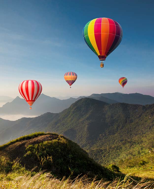 Heißluftballone über den Bergen