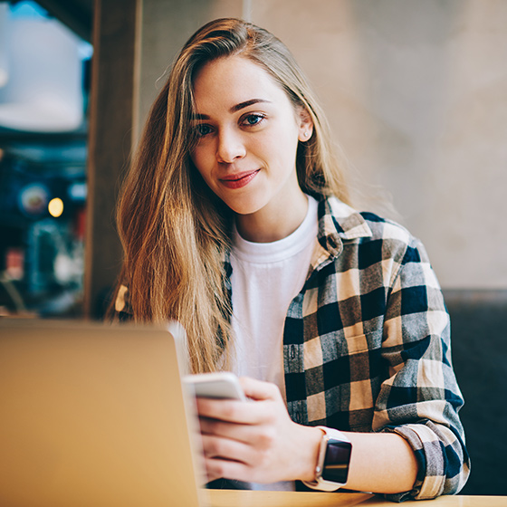 Eine junge Frau sitzt vor ihrem Laptop