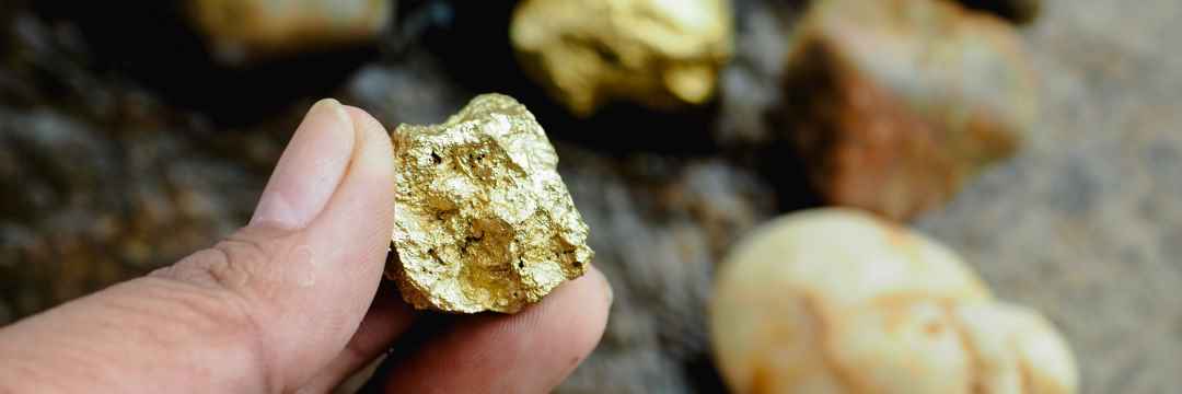 Jemand hält Goldklumpen in der Hand