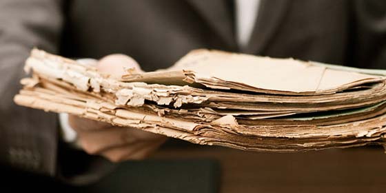 Mann hält ein sehr altes Buch in der Hand