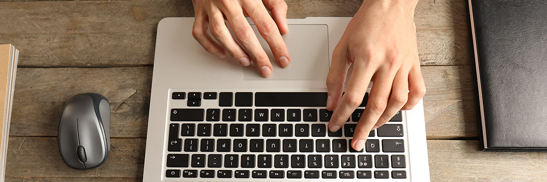 Jemand schreibt auf einer Laptop Tastatur