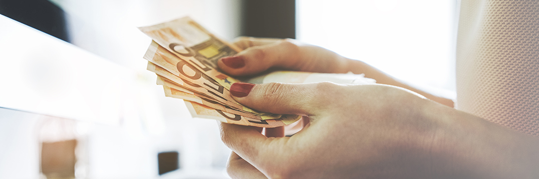 Eine Hand hält viele 50 Euro Scheine in der Hand wie einen Fecher
