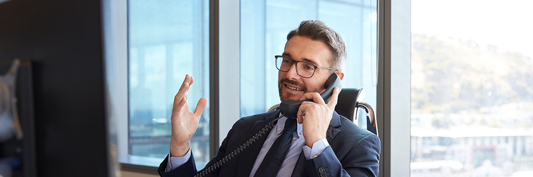 Ein Mann im Anzug telefoniert im Büro