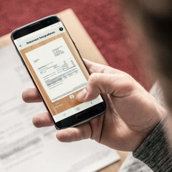 Jemand fotografiert seine Rechnung mit der MobileBanking App